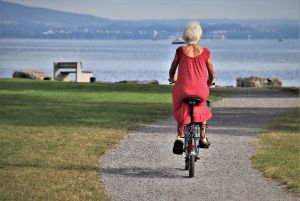 Starsza kobieta jadąca rowerem