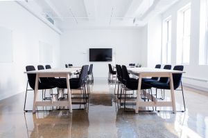 Sala konferencyjna, w której znajdują się 4 stoły i krzesła, tablice i telewizor