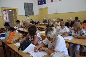 siedzący w ławkach uczestnicy programu