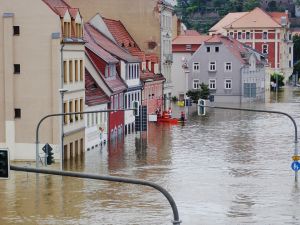 Powódź w mieście - kamienice i sygnalizacja zalane wodą.