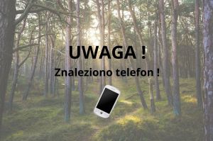 Napis "UWAGA! Znaleziono telefon!" na tle lasu, pod napisem znajduje się telefon.