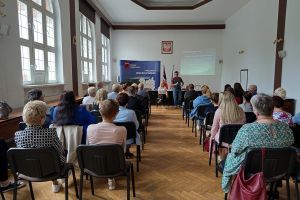 Grupa osób siedząca na wykładzie
