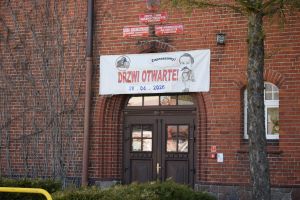 Fragment budynku ZSO w Wąbrzeźnie, napis "DRZWI OTWARTE"